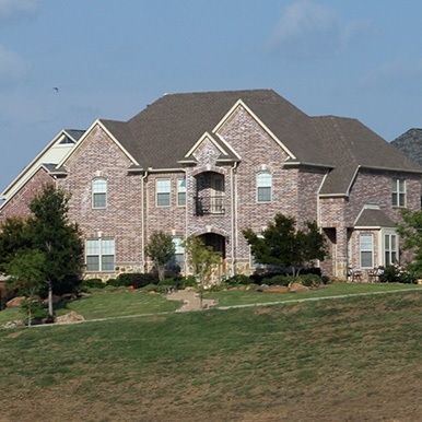 Exterior of brick home in Aubrey by Platinum Painting