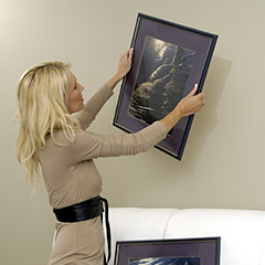 Woman taking painting down from wall