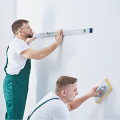 Two men prepping room for painting