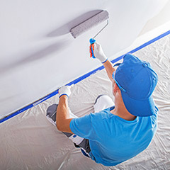 Man painting a wall with a roller brush
