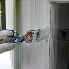 Person painting window trim