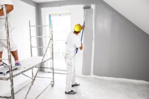 professional painter painting gray walls 