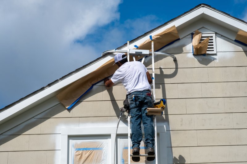 man prepping the outside of house