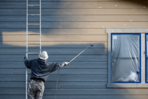 a person painting the exterior of a house
