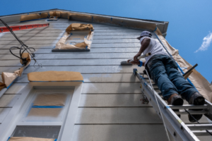 a person painting their home’s exterior